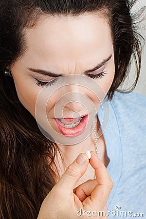 Close-up of a woman with illness taking pill Stock Photo