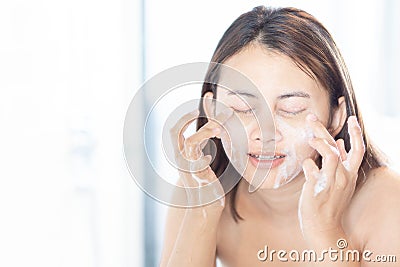 Close up woman looking reflection in the mirror for washing face with foam in the bathroom, health care and beauty concept Stock Photo