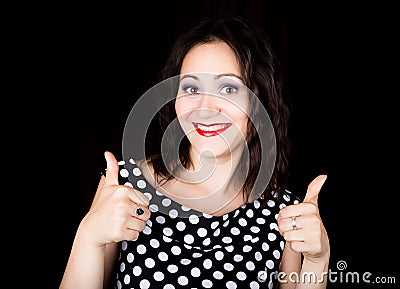 Close-up woman looks straight into the camera on a black background. shows various signs hands. expresses different Stock Photo