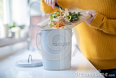 Close Up Of Woman Making Compost From Vegetable Leftovers In Kitchen Stock Photo