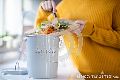 Close Up Of Woman Making Compost From Vegetable Leftovers In Kitchen Stock Photo