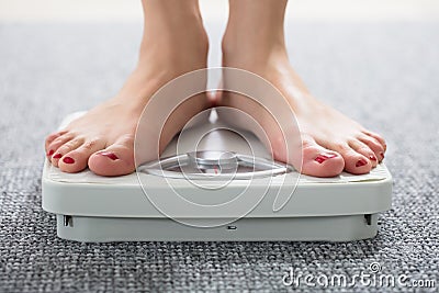 Woman`s Feet On Scale Stock Photo