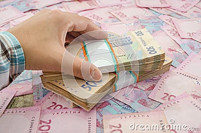 Close-up of a woman`s hand and a bundle of hryvnias. Financial concept. Ukrainian banknotes of 500 and 200 hryvnia. Many Ukrainian Stock Photo