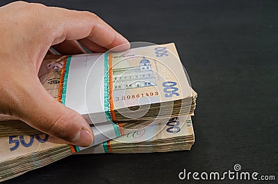 Close-up of a woman`s hand and a bundle of hryvnias. Financial concept. Ukrainian banknotes of 500 hryvnia. Many Ukrainian banknot Stock Photo