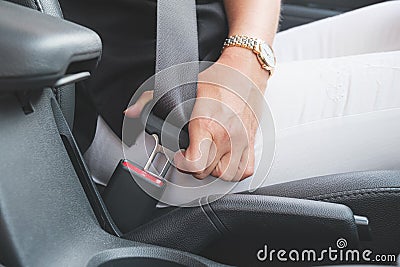 Close-up of a woman`s hand fastening a seat belt in a car Stock Photo