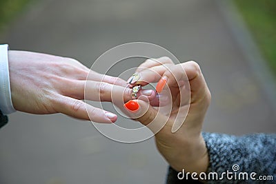 Close-up Of Woman`s Hand Putting Golden Ring On Man`s Finger Stock Photo