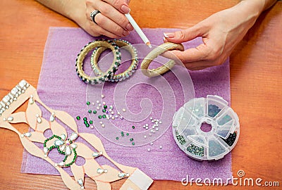 Close-up woman`s hands, decorating bracelets with colorful shiny rhinestones Stock Photo