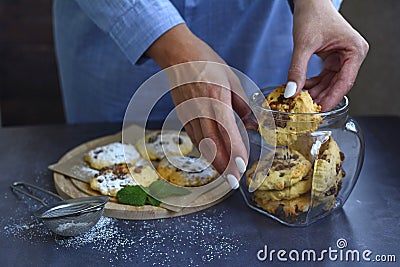 Woman`s hands stack homemade cookies in a glass jar Stock Photo
