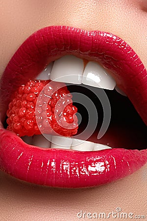 Close-up of woman's lips with bright fashion red glossy makeup. Macro bloody lipgloss make-up. Red lips. Open mouth Stock Photo