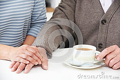 Close Up Of Woman Sharing Cup Of Tea With Elderly Parent Stock Photo