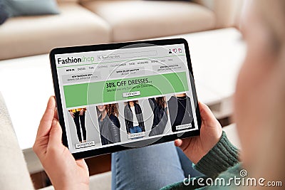 Close Up Of Woman Shopping For Clothes Online At Home Using Digital Tablet App Stock Photo