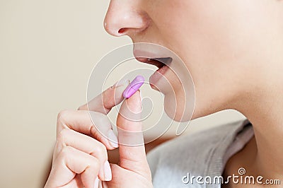 Close-up of woman taking pill Stock Photo