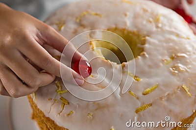 Woman toping a fresh baked cake with cherry Stock Photo