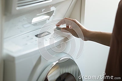 Close up of woman turn on modern washing machine Stock Photo