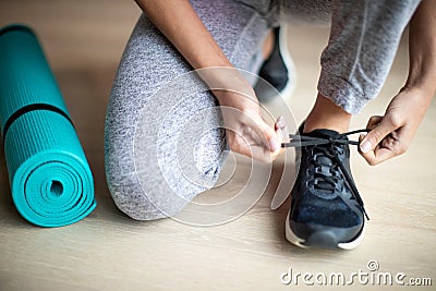 Close Up Of Woman Tying Laces Of Training Shoes Before Exercise At Home Stock Photo
