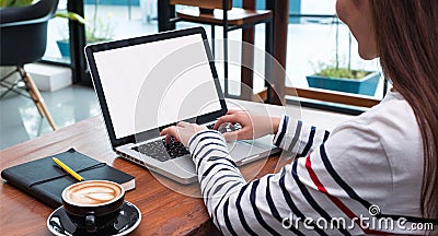 Close up woman type on laptop keyboard and looking at computer screen on table in coffee shop,Blank notebook screen mock up for Stock Photo