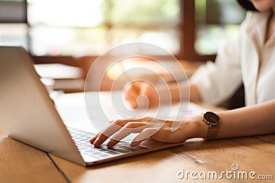 Close up of woman typing keyboard on laptop in coffee shop. People and technology concept. Freelance and Lifestyle theme. Stock Photo