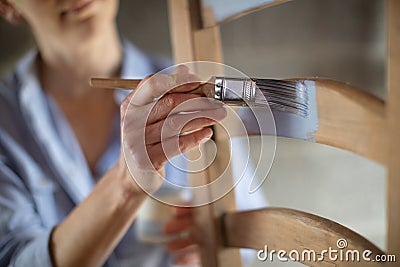 Close Up Of Woman Upcycling Furniture In Workshop At Home Painting Wooden Chair Stock Photo