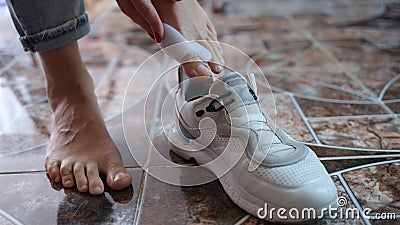 Woman using brace for hallux valgus and putting on sneaker Stock Photo