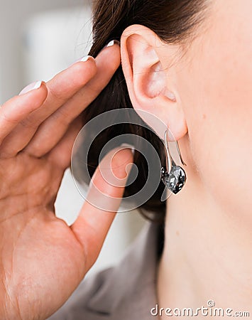 Close-up woman wearing beautiful luxury earrings. Handmade jewellery and accessories. Stock Photo
