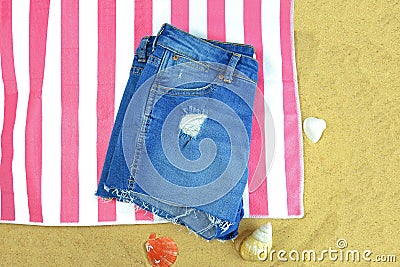 Close up of women denim shorts on a towel on the beach Stock Photo