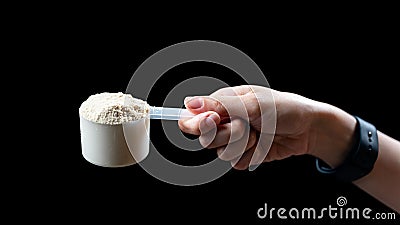 Close up of women hand holding a measuring scoop of whey protein preparing protein shake Stock Photo