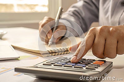 Close-up of women using calculators and note-taking, accounting reports. Stock Photo