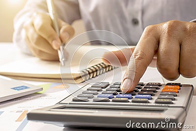 Close-up of women using calculators and note-taking, accounting reports. Stock Photo