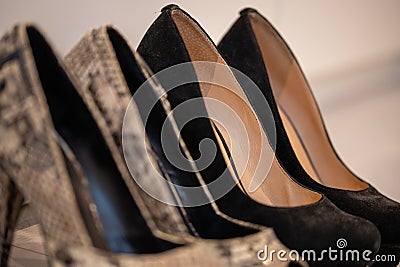 A close up of a women's shoe, snake leather peep toe and black suede pumps Stock Photo