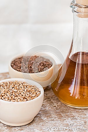 Wheat grains in wooden bowl and oil in decanter Stock Photo