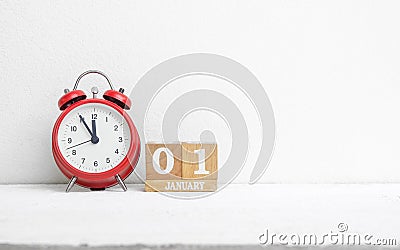 Close up of wooden calendar date 01 January with red alarm clock Stock Photo