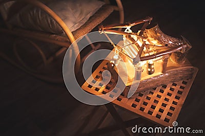 Close-up wooden lampshade with backlight and rocking chair in a poorly lit bedroom at night. Home comfort concept Stock Photo