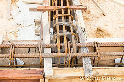 Close up of wooden mold with steel rod forming the foundation beam at construction site Stock Photo