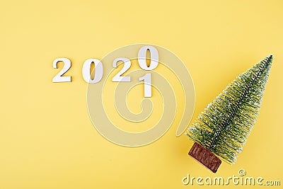 Close-up of wooden numbers 2021 on orange background with stars and cristmas tree . Change year 2020 to 2021 Stock Photo