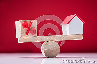 Seesaw Showing Balance Between Percentage Symbol And House Model Stock Photo
