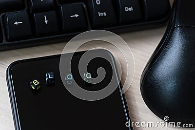 Close up words BLOG on blocks on black smart phone on desk Stock Photo