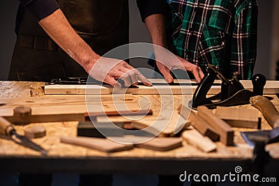 Close-up of the work of a man and a boy at a carpenter`s table, on the table are a plane, chisel, Board, workbench Stock Photo