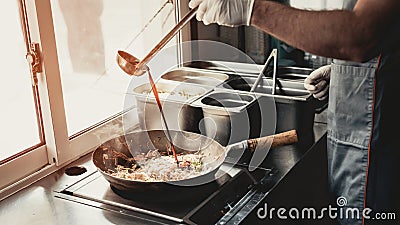Close up. Worker Cooking Tasty Food in Food Truck. Stock Photo