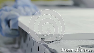 Close-up worker hand polishing wooden board. Action. Worker with gloves polishing sandpaper wooden board. Whetstone is Stock Photo