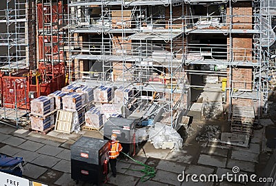 Close up of worker on his back materials and scaffolding on construction site. Nottingham, England 17 February 2020. Editorial Stock Photo