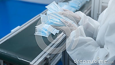 Close up of worker producing surgical mask in modern factory, Covid-19 protection and medical concept Stock Photo