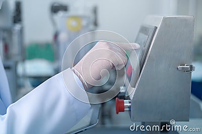 Close up of worker producing surgical mask in modern factory, Covid-19 protection and medical concept Stock Photo