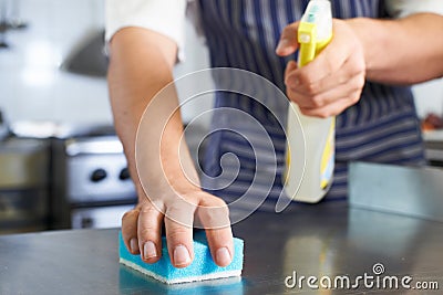 Close Up Of Worker In Restaurant Kitchen Cleaning Down After Service Stock Photo