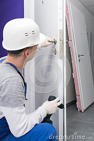 Close-up of a worker in uniform, checking the correct operation of the lock of the door mechanism, after replacing and repairing Stock Photo
