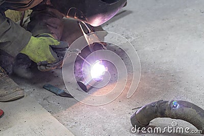 Close-up. Worker weld stainless steel metal products. Establishes a seam Stock Photo