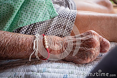 Close up wrinkled skin of old senior woman hands, bedridden patient Stock Photo