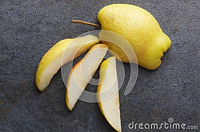 Close up of yellow fresh pear on dark table,top view.Pieces and half of tasty juicy pear Stock Photo