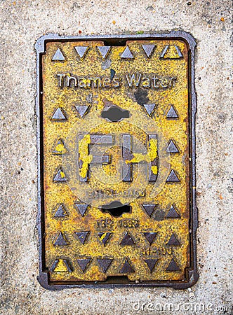 A close-up of a yellow painted Thames water fire hydrant cover. Editorial Stock Photo