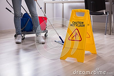 Close-up Of Yellow Wet Floor Caution Sign Stock Photo