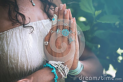 close up of yoga woman hands in namaste gesture with lot of boho style jewelry rings and bracelets outdoor Stock Photo